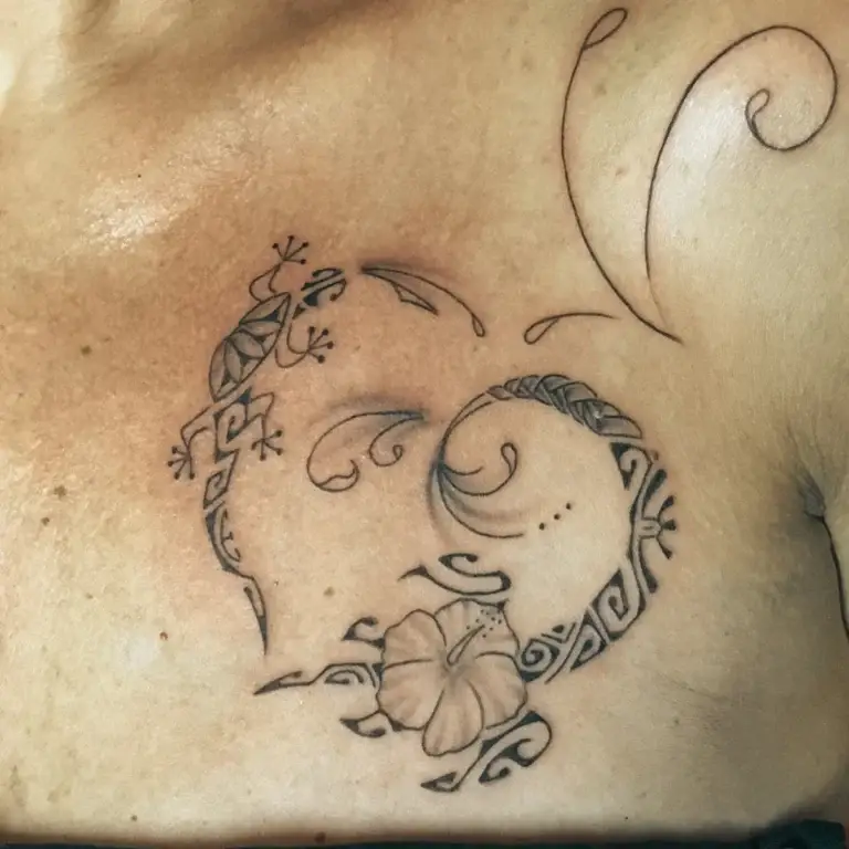 Tatouage polynésien en forme de cœur avec un gecko et un hibiscus sur le haut du buste, réalisé par Karine chez Kanea à Toulon