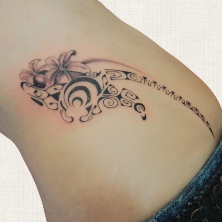 Tatouage polynésien d'une raie et de fleurs de frangipanier sur la hanche, réalisé par Karine chez Kanea à Toulon