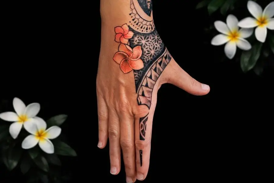 Tatouage polynésien sur main avec mandala dotwork et fleurs de tiaré orange réalisé au studio Kanea à Toulon