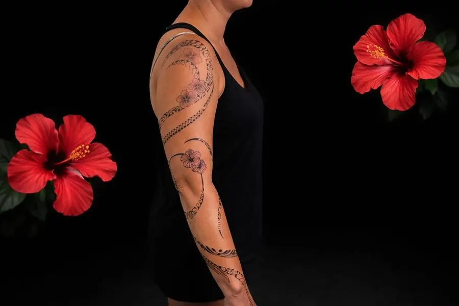 Tatouage polynésien féminin sur bras complet avec motifs tribaux et hibiscus rouges au studio Kanea Toulon