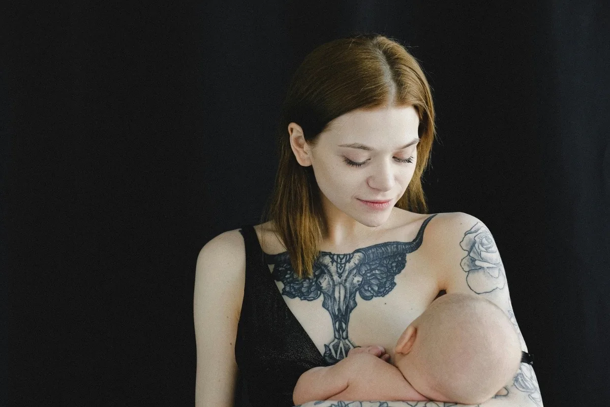 Femme tatouée portrait élégant avec son bébé tatouages compatibles avec la maternité après sevrage à Toulon Kanea